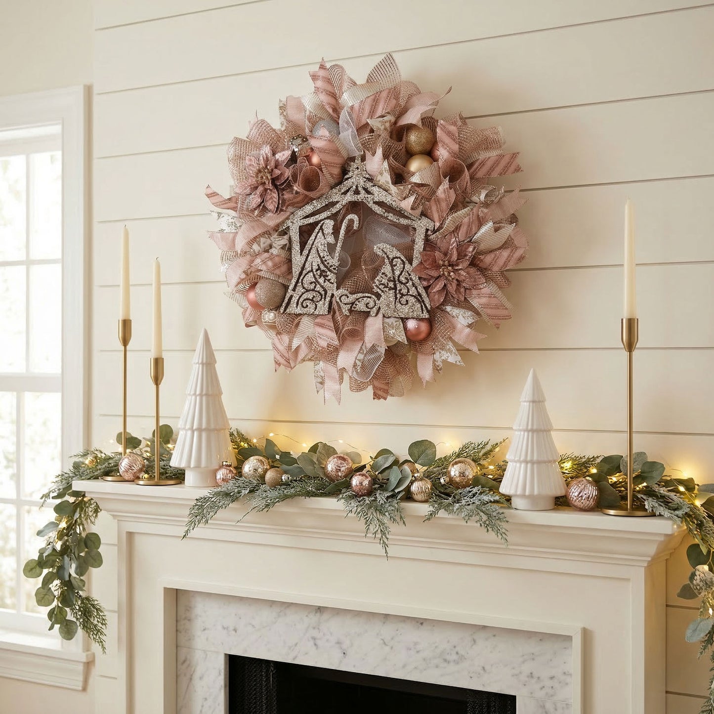 Rose Gold Nativity Wreath with Champagne and White Accents styled on a modern farmhouse mantel. Mums and Garters Seasonal Wreath Collection features a glittered manger silhouette, rose gold ornaments, and snowflake ribbons for elegant holiday home decor.