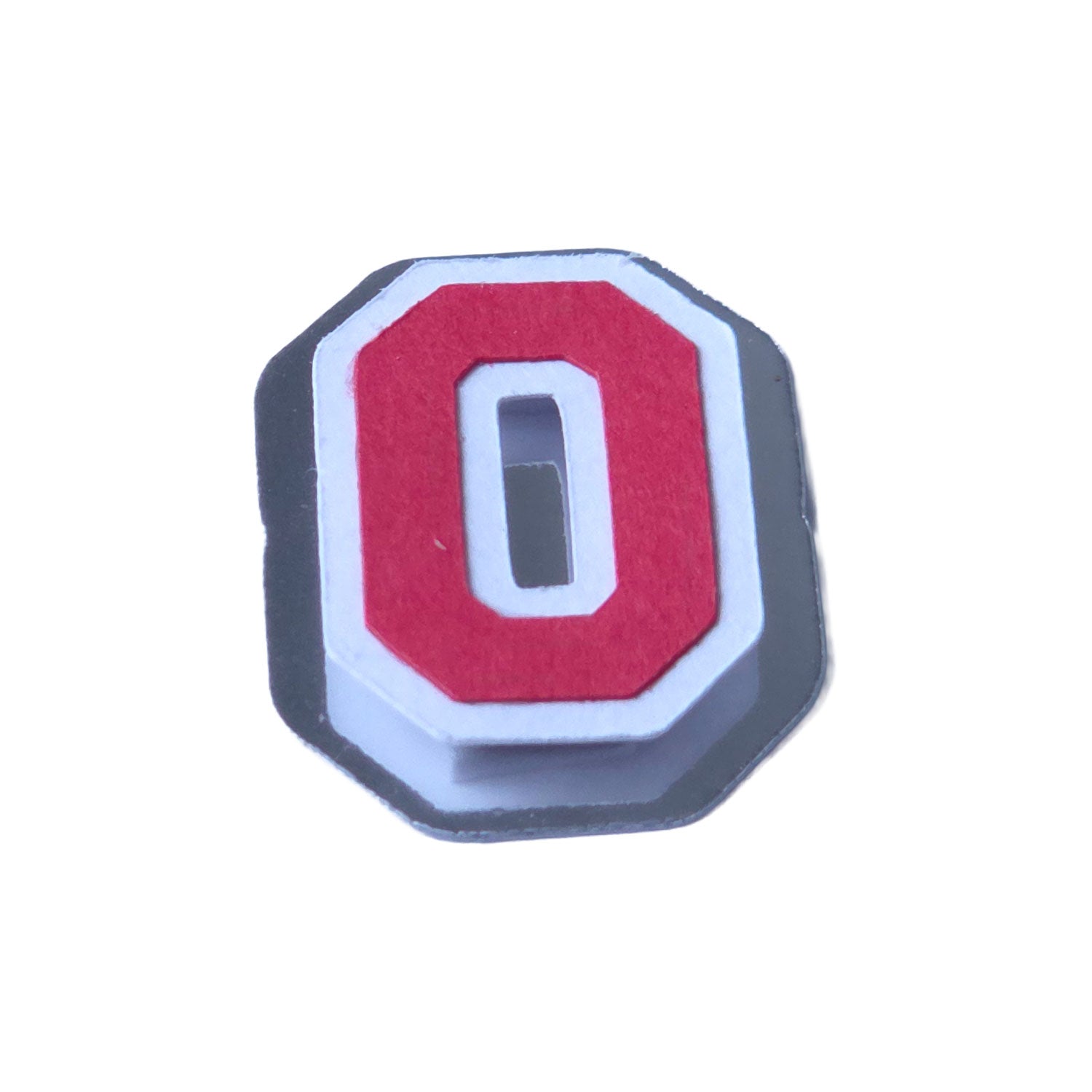 Angled 3D view of a red and silver foil layered cardstock number 0, showing the metallic silver foil base and crisp white offset border.