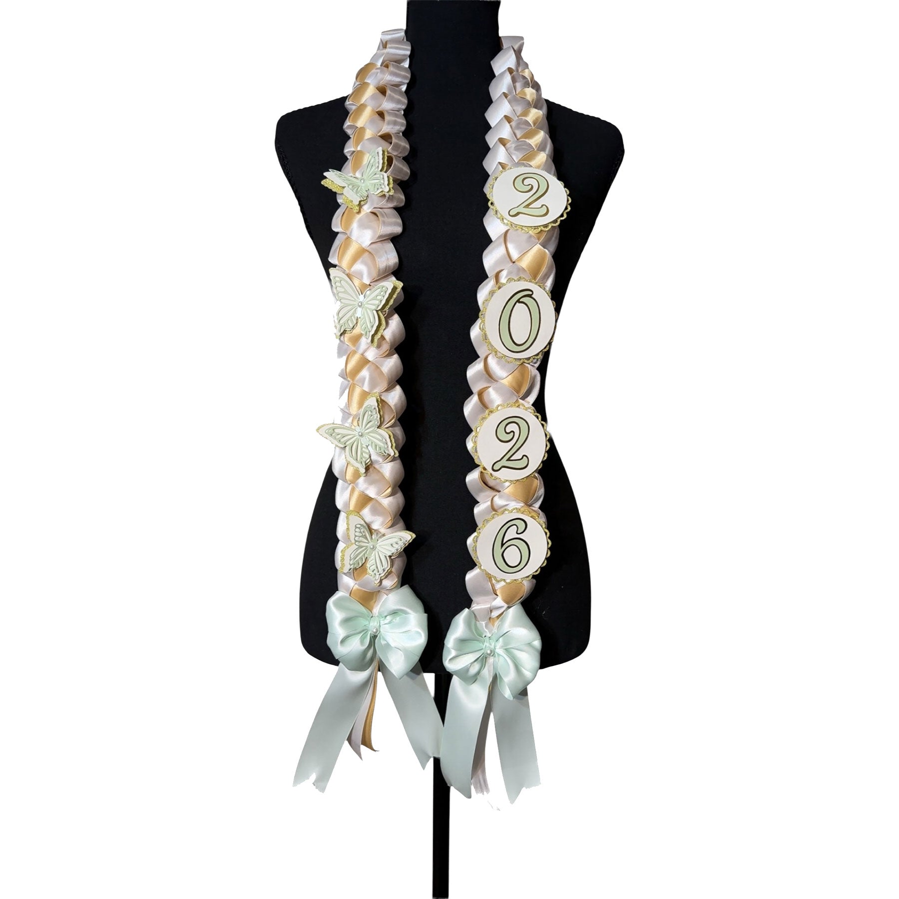 Front view of a 2026 graduation lei featuring a mint green, gold, and white single military braid design with layered mint butterfly accents and year charms on a black display mannequin.