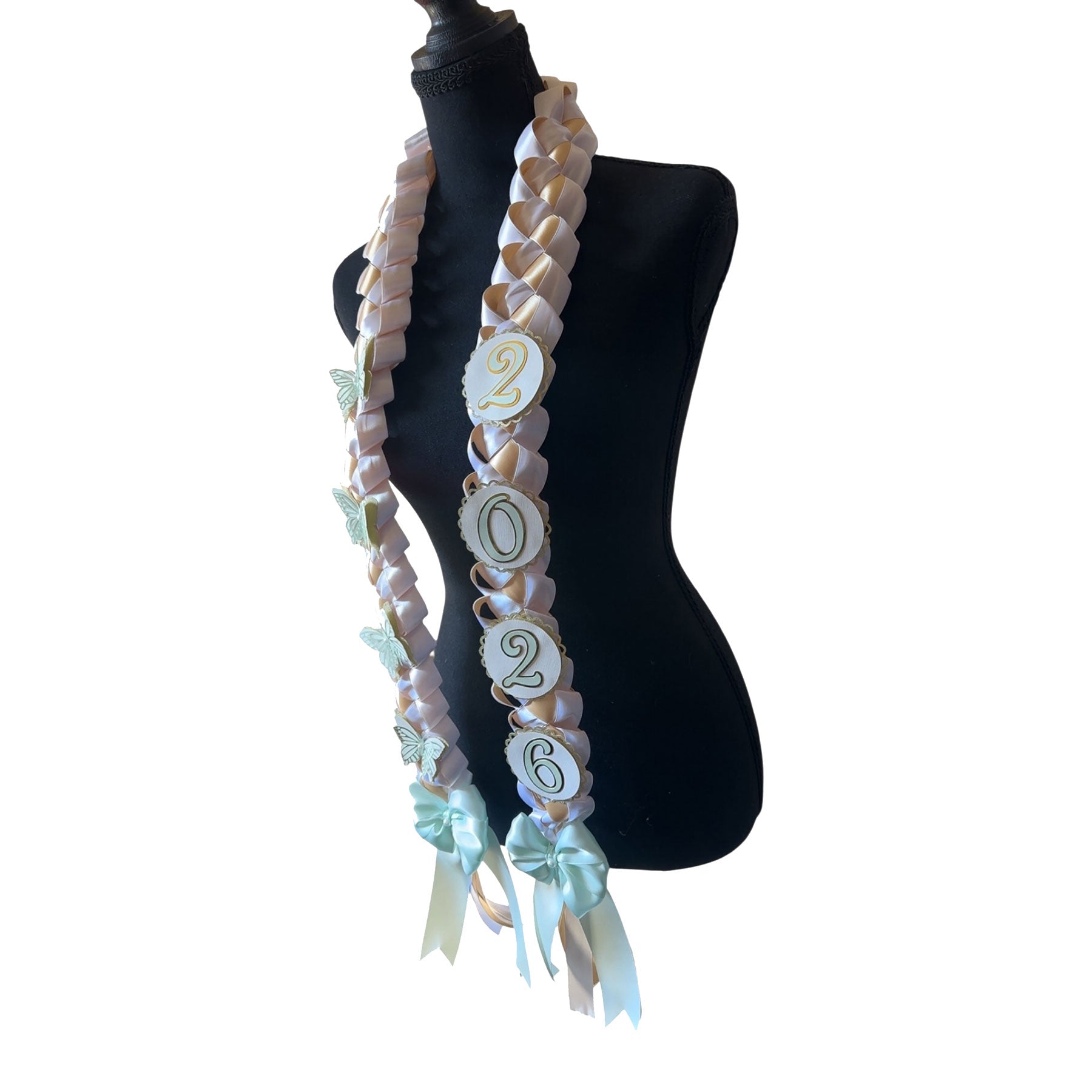 Angled view of a 2026 commemorative graduation lei highlighting the "2026" circular charms and the large mint green satin bows at the base of the white and gold military braid.
