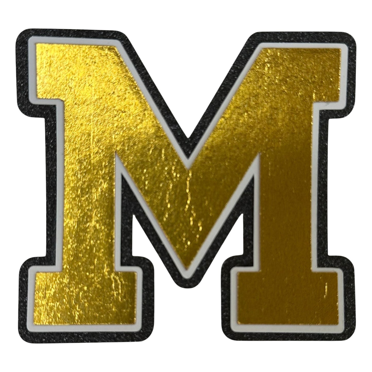 Black white and gold foil layered cardstock letter M cutout in varsity font for homecoming mums and graduation leis.