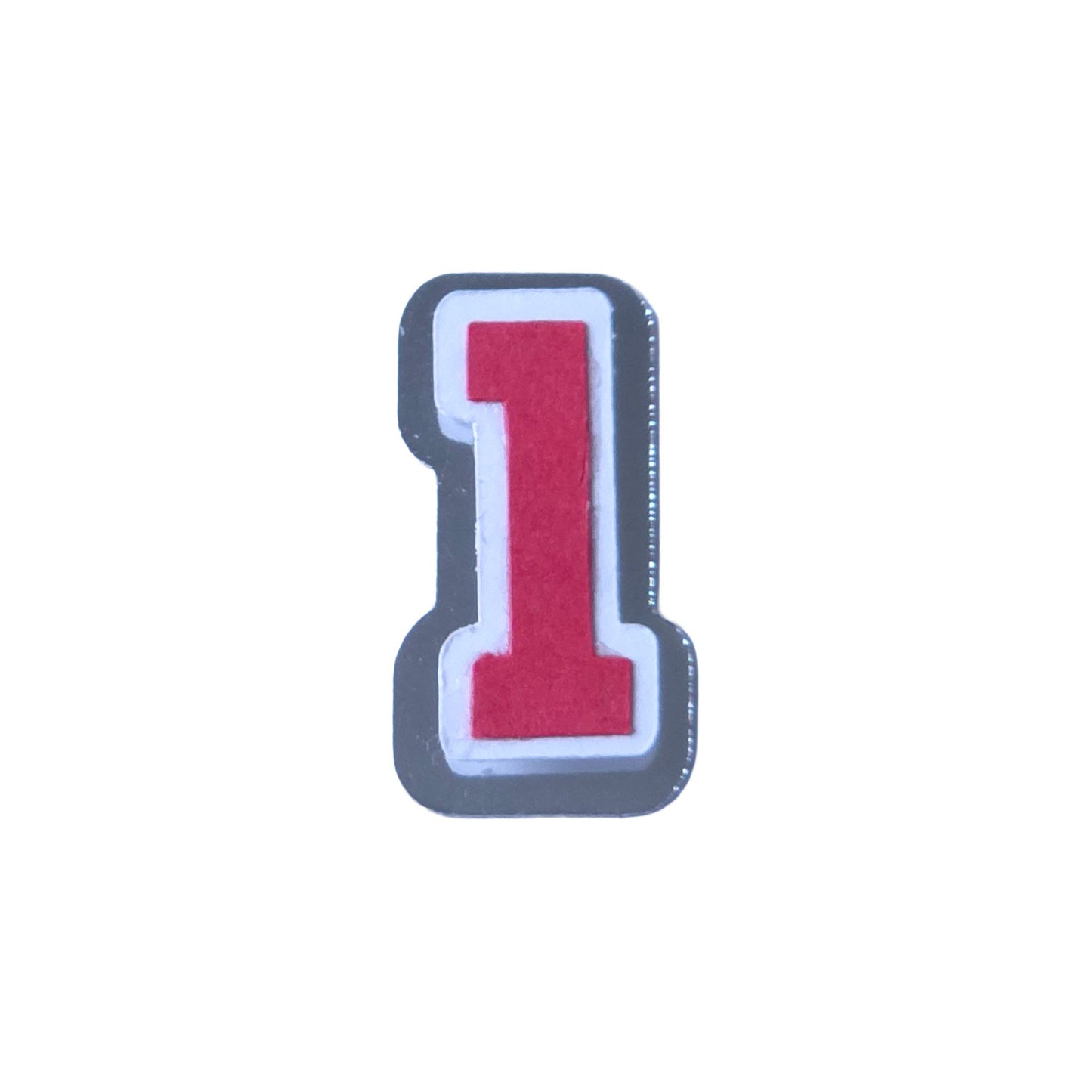 Red, white, and silver foil layered cardstock number '1' cutout in a varsity block font for homecoming mums and graduation leis.