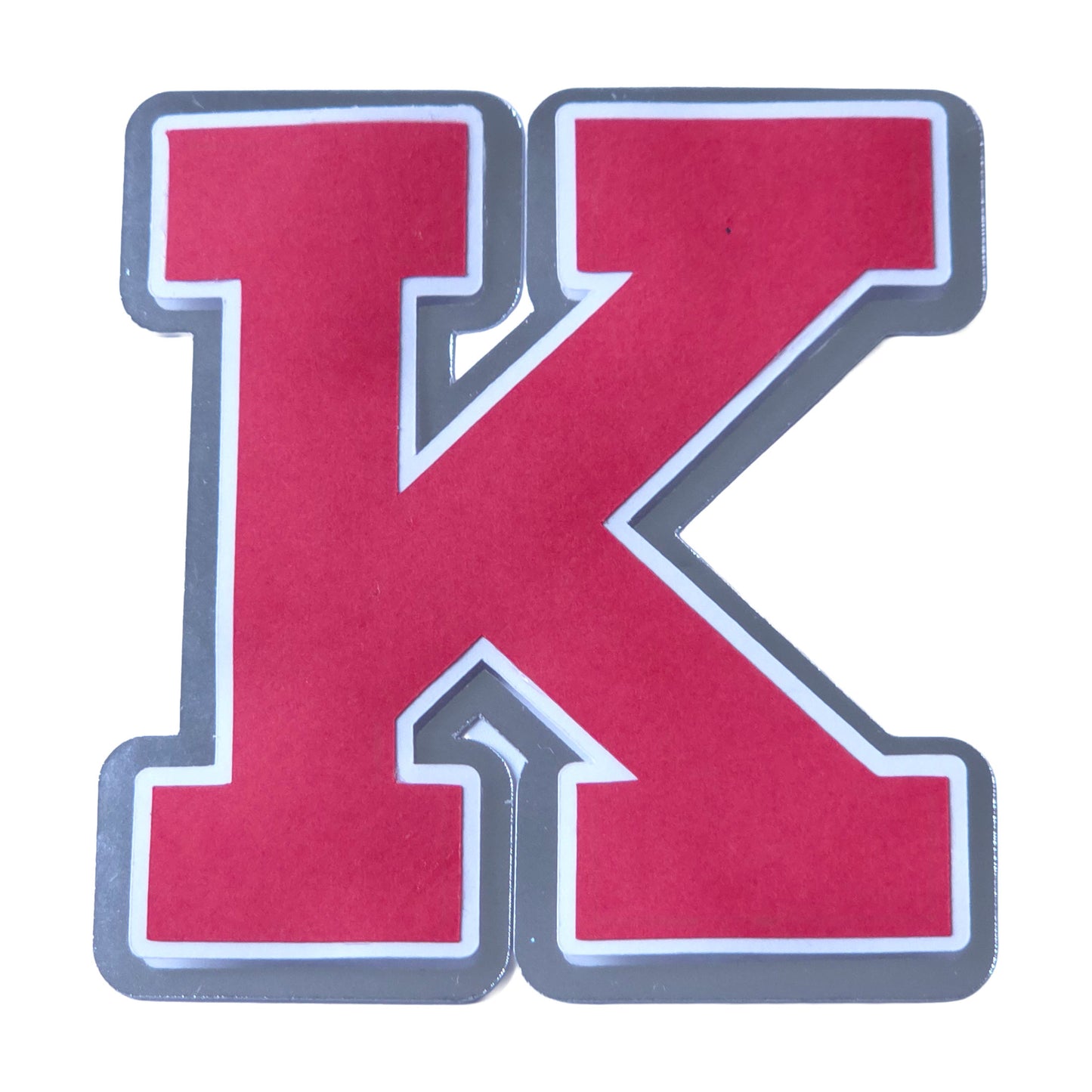Red, white, and silver foil layered cardstock letter K cutout in a classic varsity block font for homecoming mums and graduation leis.